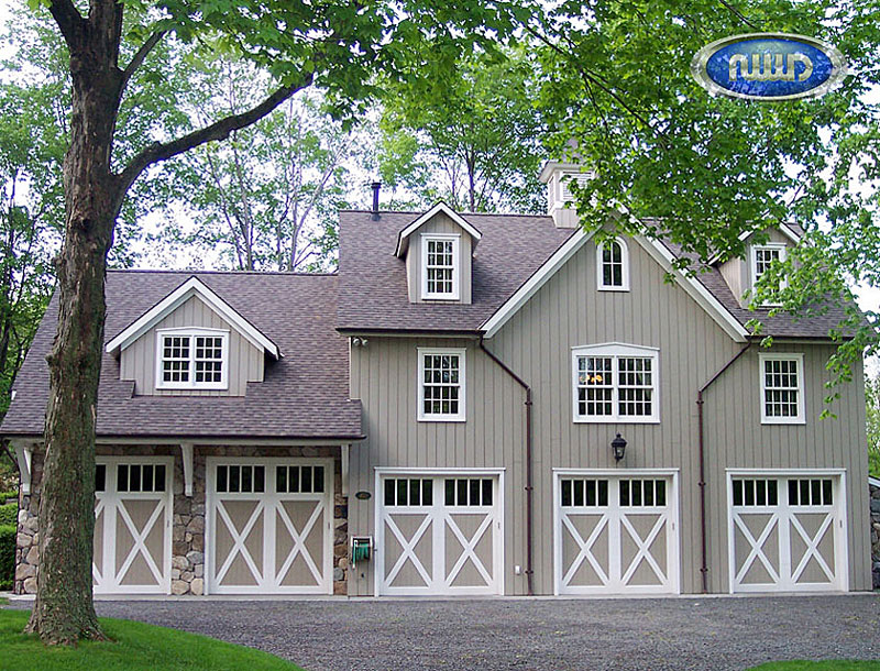 3 Story house with 5 white wood garage doors